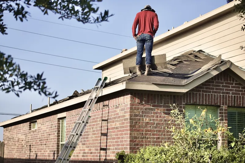 Professional roofer working on a residential roof in Alliance